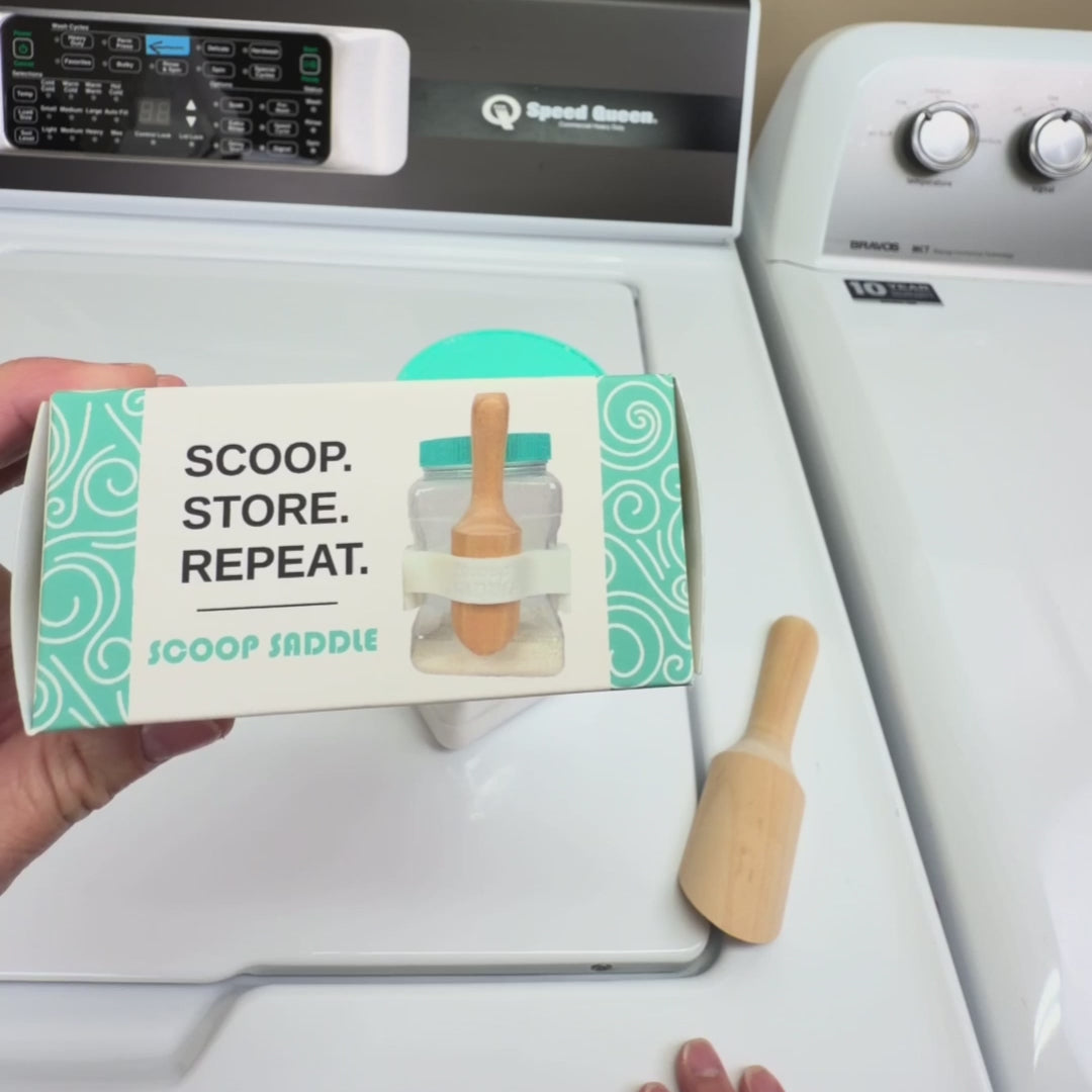 Video demonstration showing how The Scoop Saddle clips onto Buff City Soap laundry detergent jars to securely hold wooden scoops, creating an organized, Pinterest-style laundry shelf